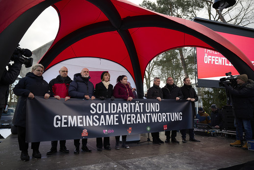Gewerkschaftsvertreter und Arbeitgebende stehen gemeinsam hinter einem Plakat mit der Aufschrift: Solidarität und gemeinsame Verantwortung.at