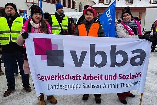Streikteilnehmer der vbba hinter einem vbba-Banner