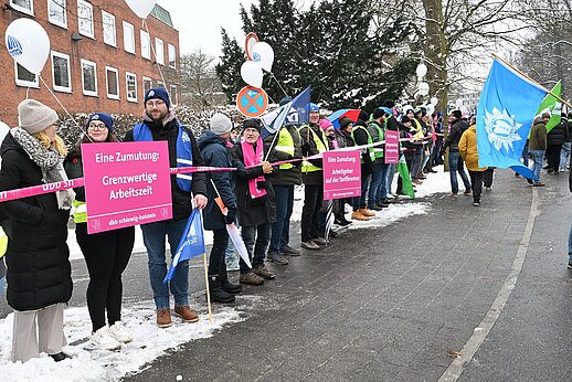 Demonstrierende in einer Menschenkette in Kiel