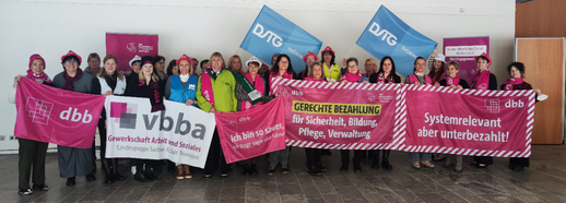 Das Foto zeigt eine Gruppe von Frauen mit Bannern und Fahnen ihrer Gewerkschaften in der Hand.
