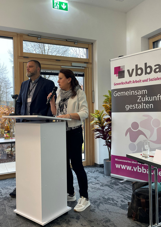 Ina Kastner und Oliver Gerdelmann am Rednerpult vor dem vbba Roll Up