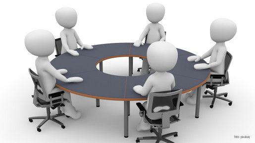 Figuren an einem runden Tisch in einer Besprechung