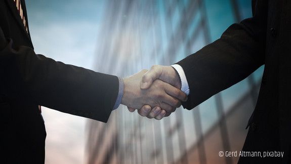 Zwei Personen schütteln sich die Hand.
