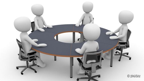 Figuren an einem runden Tisch in einer Besprechung